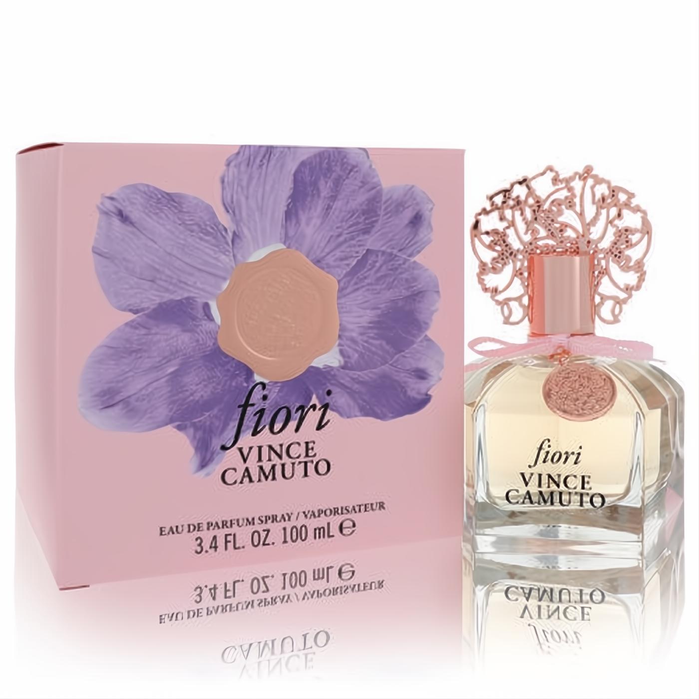 Elegant Vince Camuto Fiori 3.4 oz EDP. Features a clear faceted bottle, ornate rose gold cap, and a beautiful pink box with a purple flower.
