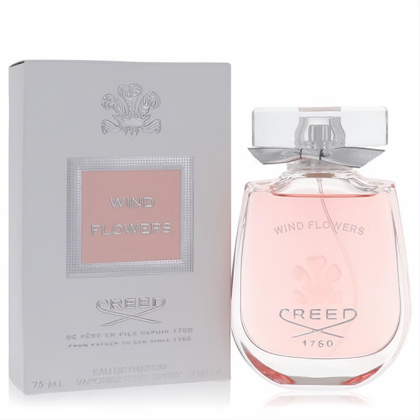 Luxurious Creed Wind Flowers 2.5 oz Eau De Parfum spray. Elegant pink liquid in a clear glass bottle with silver ribbon, beside its white box.