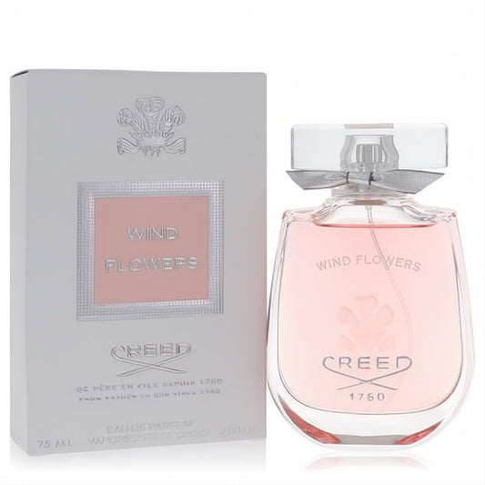 Luxurious Creed Wind Flowers 2.5 oz Eau De Parfum spray. Elegant pink liquid in a clear glass bottle with silver ribbon, beside its white box.
